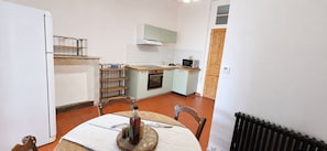 A compact kitchen with a dining table, a microwave, and a built-in oven.