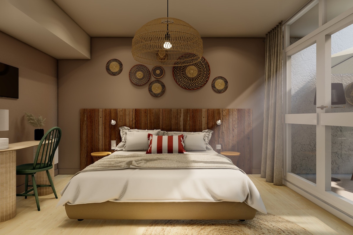 Ein modernes Schlafzimmer mit einem großen Bett, einem Schreibtisch, einem Sessel und einem großen Fenster.
