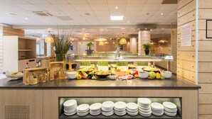A buffet counter with various food items, plates, and a wooden interior. - La Grande Motte "Le Ponant" (La Grande-Motte)