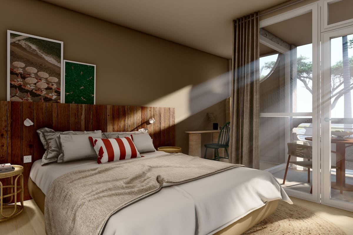 A bedroom with a wooden headboard, a large bed with white bedding, a small round side table, a chair, and a view of the outdoors through a glass door.