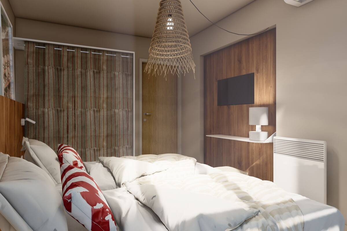 A modern bedroom with a bed, a hanging light fixture, a television, and a bedside table.
