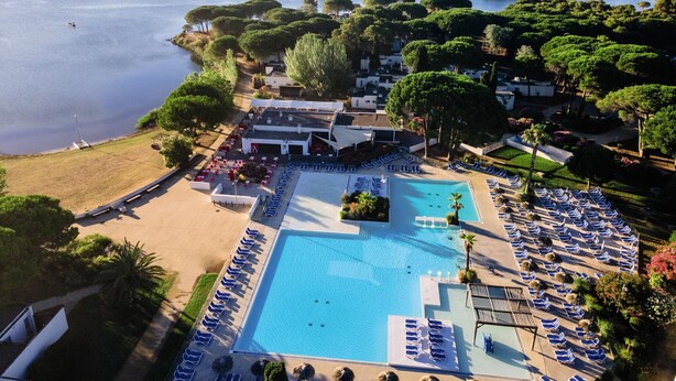 An aerial view of a resort with a large swimming pool, sun loungers, and a beach area. - La Grande Motte "Le Ponant" (La Grande-Motte)