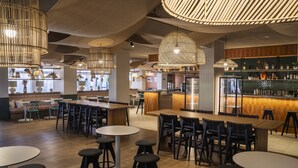 A modern restaurant interior with high ceilings, hanging pendant lights, and a bar area. - La Grande Motte "Le Ponant" (La Grande-Motte)