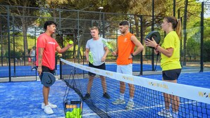 A tennis court with a net, players, and tennis balls.