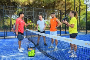 A tennis court with a net, players, and tennis balls. - La Grande Motte "Le Ponant" (La Grande-Motte)