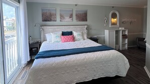 A bedroom with a bed, a ceiling fan, a window, and a view of the outside. - Welcome to Sea Clearly, a newly remodeled first floor oceanfront condo in OIB (Ocean Isle Beach)