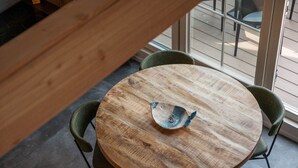 Una mesa redonda de madera con un cuenco decorativo, rodeada por cuatro sillas.