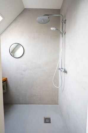 A shower with a handheld showerhead, a wall-mounted faucet, and a round mirror. - De Witte Brugh - Studio 2 by Interhome (Buren FR)