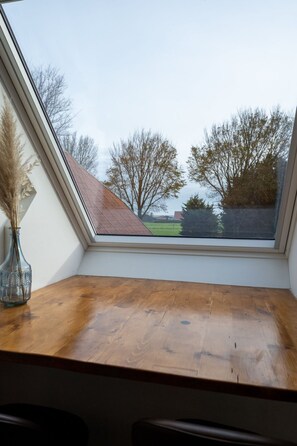 A skylight with a view of trees and a building. - De Witte Brugh - Studio 2 by Interhome (Buren FR)