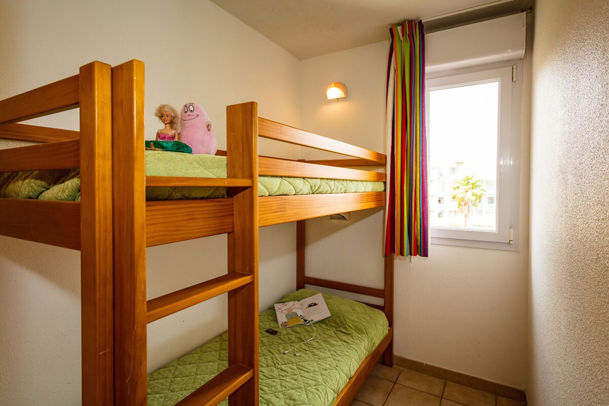 Habitación con literas, ventana y cortina.