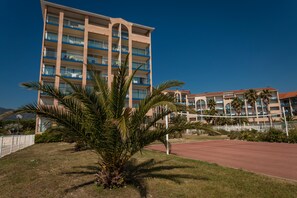 A multi-story hotel with balconies, palm trees, and a clear sky. - Résidence Appart-hôtel Argelès-sur-mer (Argelès-sur-Mer)