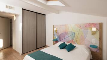 Un dormitorio moderno con tragaluz, una cama grande con almohadas turquesa, un colorido cuadro abstracto en la pared y un cabecero de madera.