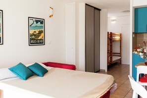 A bedroom with a bed, pillows, a wardrobe, a desk, and a chair.