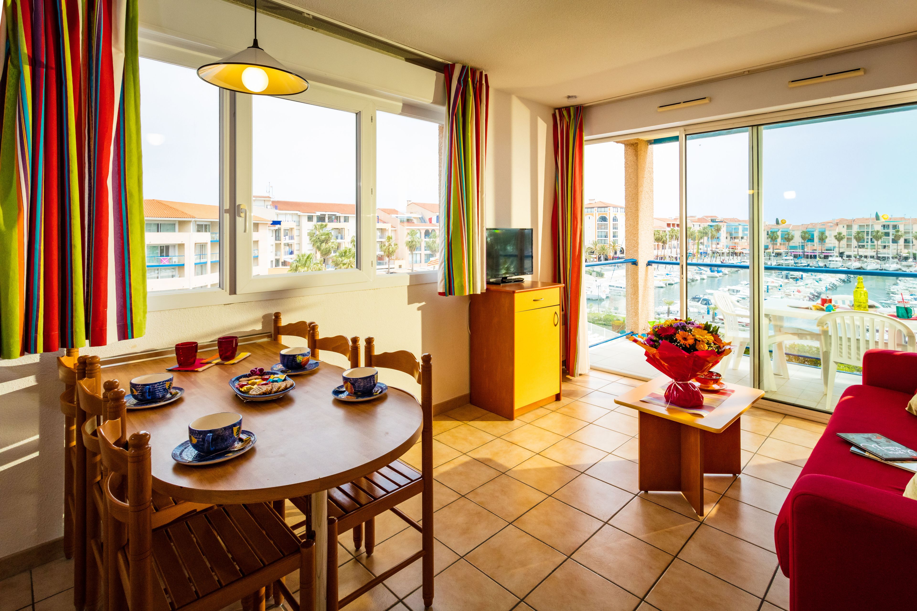 Un comedor con una mesa, sillas y un mueble para televisión.
