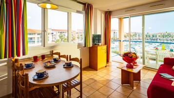 Un comedor con una mesa, sillas y un mueble para televisión.