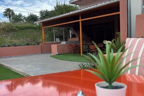 A patio area with a brick floor, outdoor seating, and a potted plant. - Aquarius Beach Hotel (Corfu)