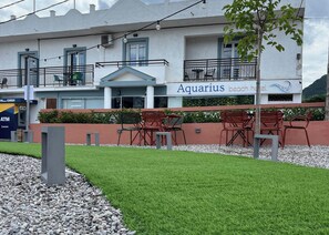 A hotel named 'Aquarius Beach Hotel' with outdoor seating and a well-maintained lawn. - Aquarius Beach Hotel (Corfu)