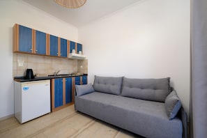 Una cocina compacta con refrigerador empotrado, estufa y armarios azules.