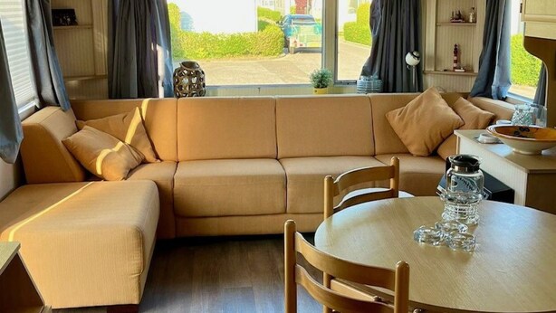 Ein gemütliches Wohnmobil-Interieur mit einer Sitzecke, einem Esstisch und Stühlen.