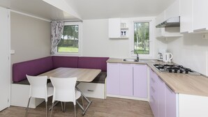 A compact kitchen with a dining area, a window with a view, and a built-in stove.