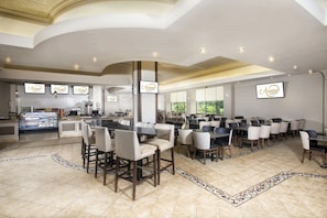 A spacious restaurant with multiple dining tables and chairs, a kitchen area, and a display case with food items. - Caesars Southern Indiana Hotel Casino (Elizabeth)