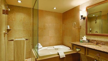 A modern bathroom with a glass shower enclosure, a freestanding bathtub, and a large mirror.