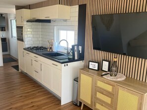 Eine moderne Küche mit Einbauherd, Spüle und Holzschränken.