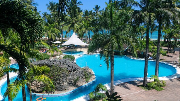 A resort with multiple swimming pools, palm trees, and a beach area. - Diani Reef Beach Resort & Spa (Diani Beach)