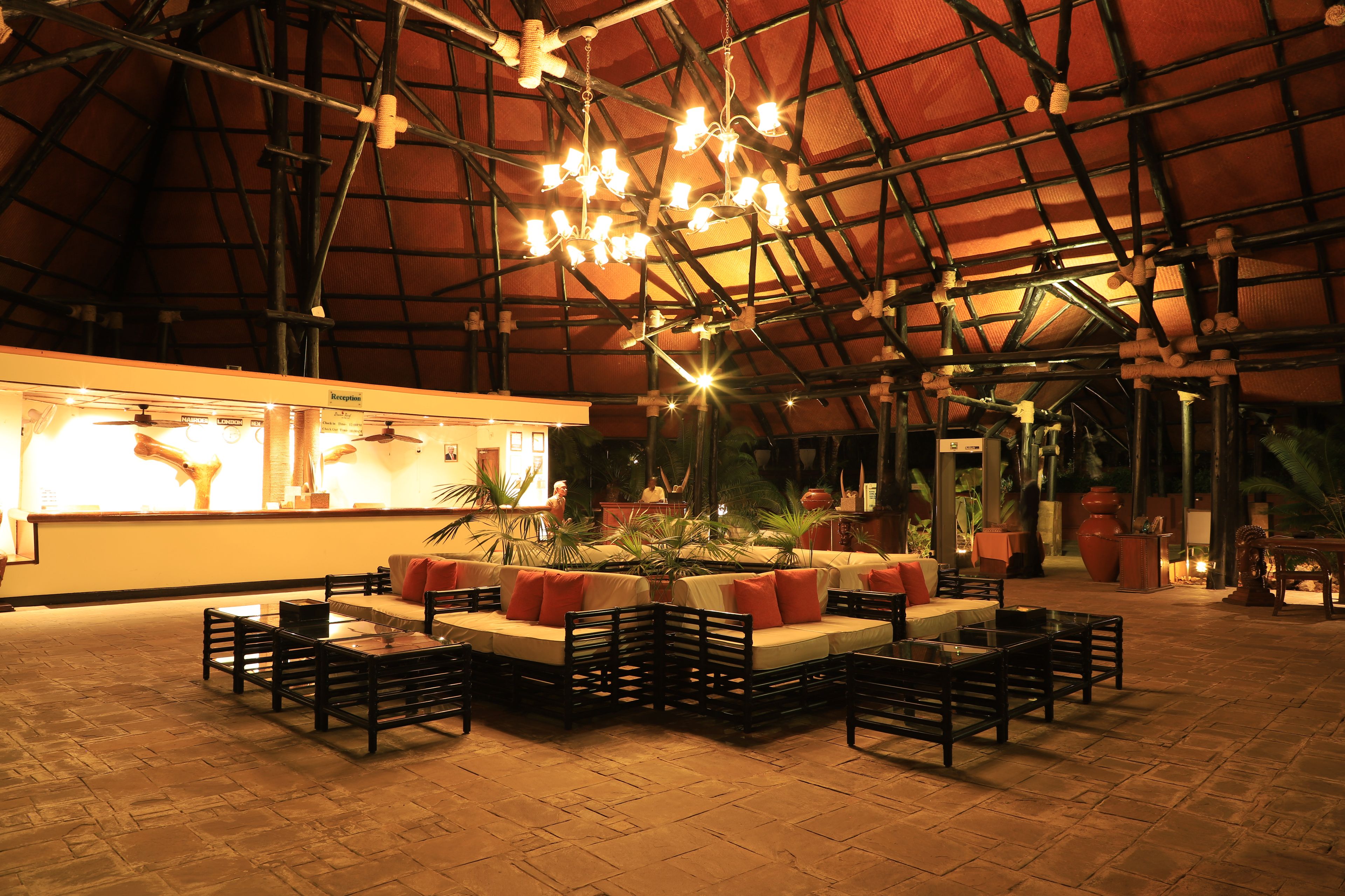 A spacious indoor area with a high ceiling, multiple seating arrangements, and a reception desk.