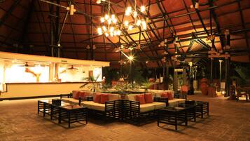 A spacious indoor area with a high ceiling, multiple seating arrangements, and a reception desk.