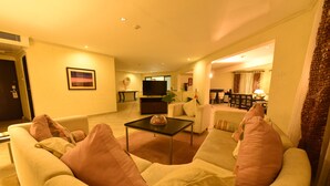 A living room with a sofa, armchairs, a coffee table, and a TV. - Diani Reef Beach Resort & Spa (Diani Beach)