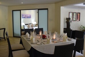 A dining area with a table set for four, featuring white tablecloths, candles, and glassware. - Diani Reef Beach Resort & Spa (Diani Beach)