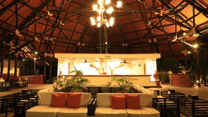 A spacious indoor area with a high ceiling, a reception desk, seating arrangements, and potted plants. - Diani Reef Beach Resort & Spa (Diani Beach)