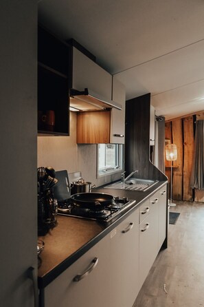 Eine moderne Küche mit Gasherd, Spüle und Fenster.