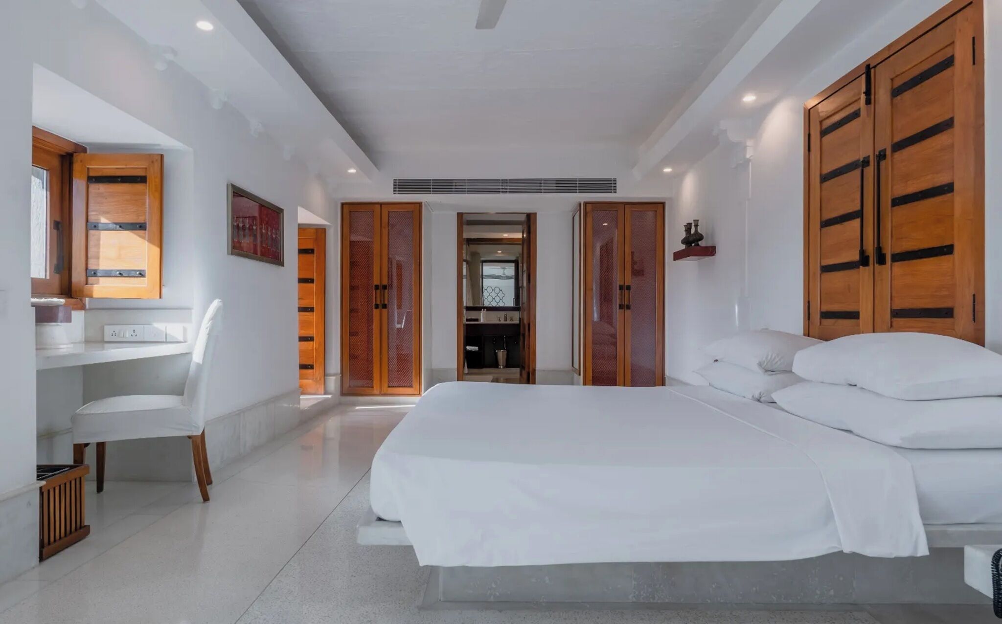 A bedroom with a bed, a desk, and a chair.