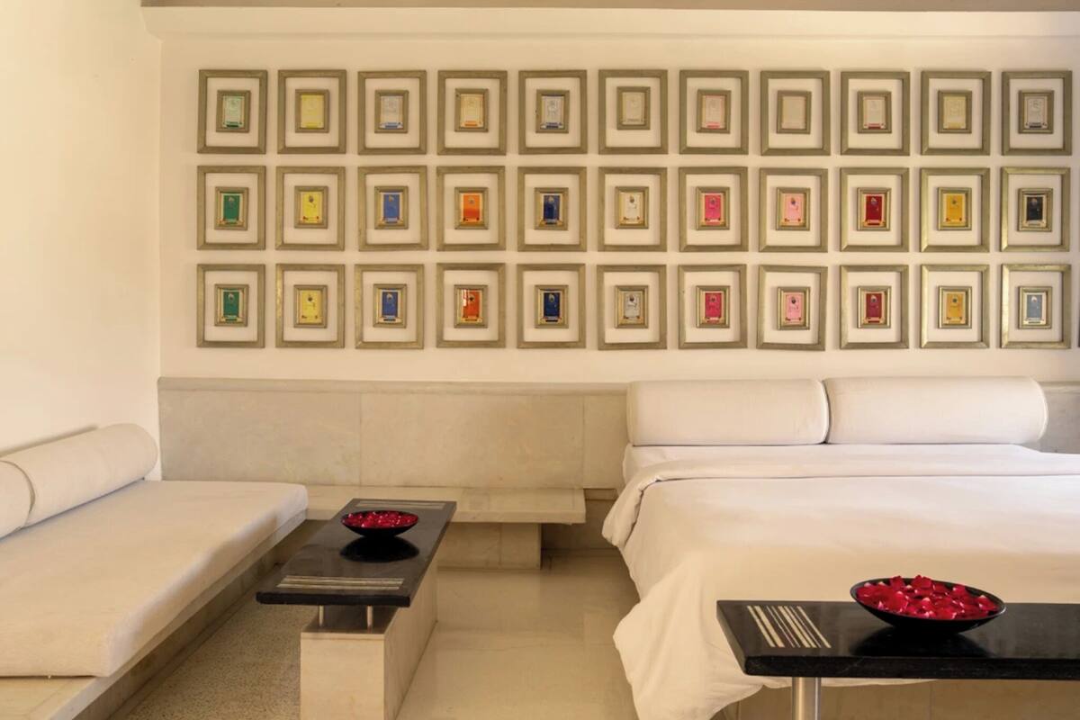 Une chambre d’hôtel comprenant un lit, un canapé, une petite table et un mur décoré de certificats encadrés.