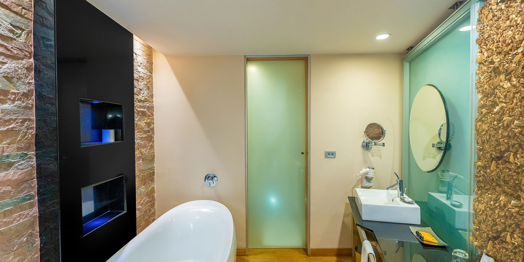 Une salle de bain moderne avec une baignoire sur pieds, une douche à parois de verre et un meuble-lavabo doté d’un grand miroir.
