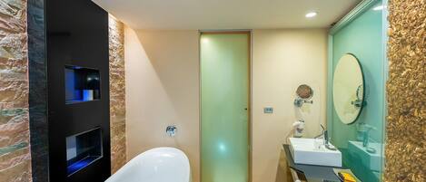 A modern bathroom with a freestanding bathtub, a glass-enclosed shower, and a vanity with a large mirror.