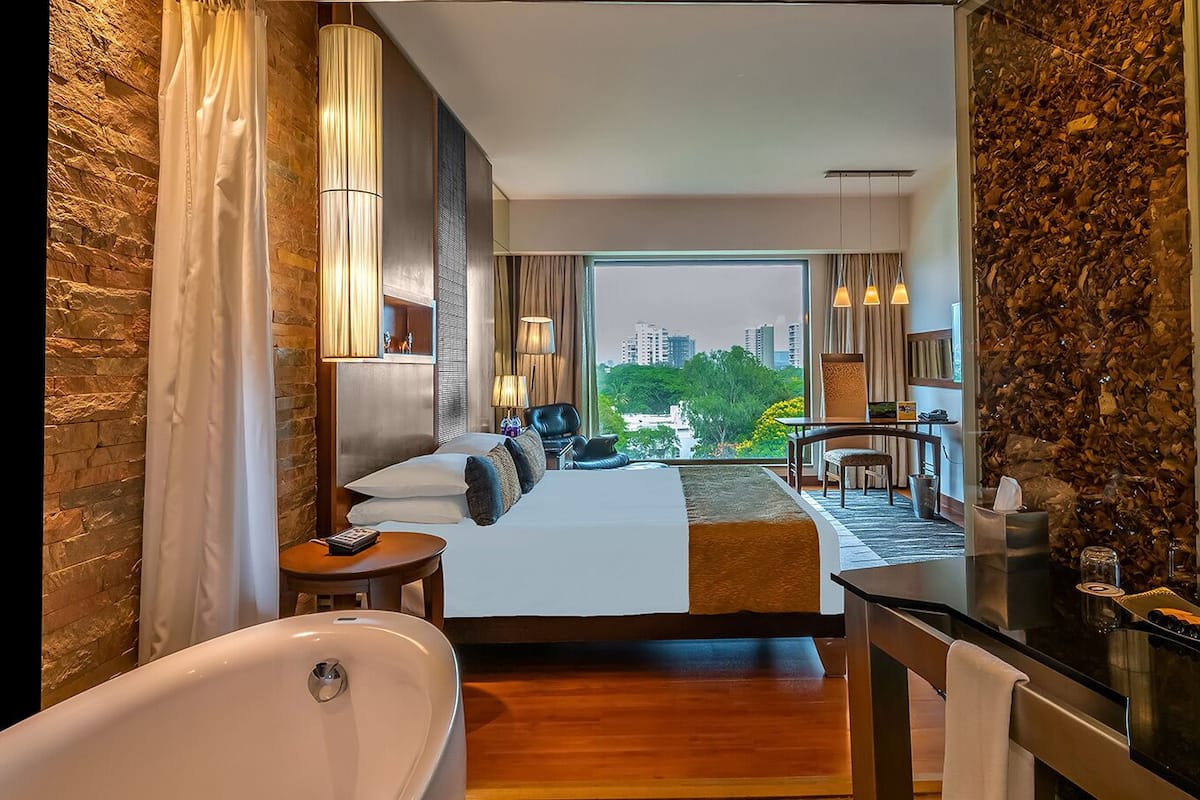 Habitación de hotel con cama, baño y vistas a la ciudad.