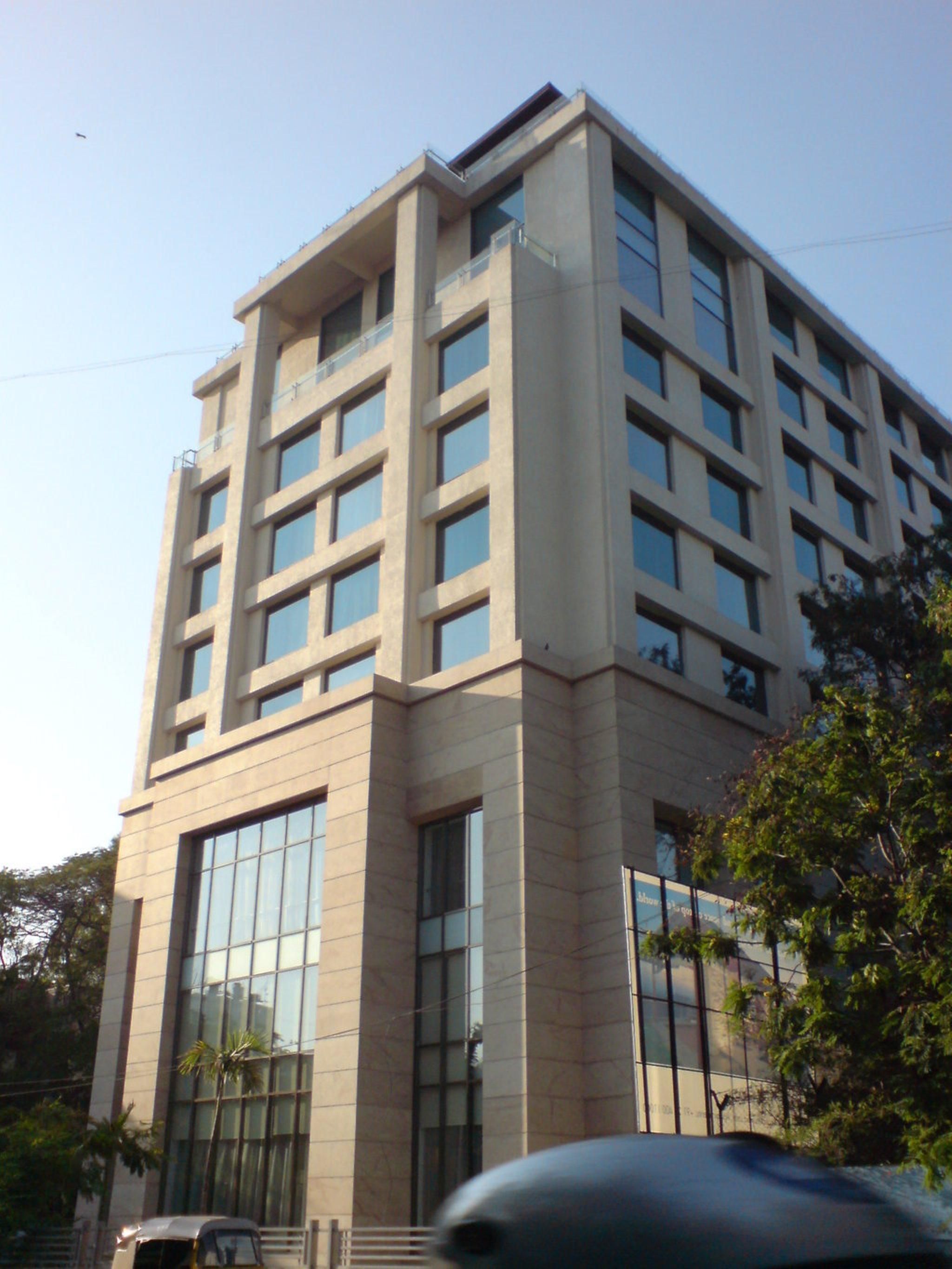 A multi-story building with a modern architectural style, featuring large windows and a flat roof.