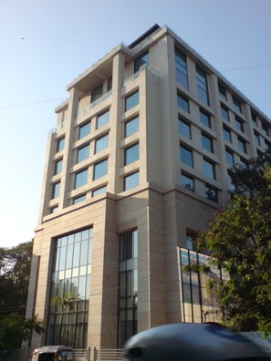 Um edifício de vários andares com arquitetura moderna, caracterizado por grandes janelas e um telhado plano.