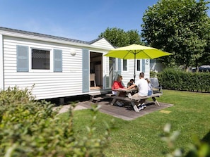 Ein Wohnmobil mit einer Terrassenfläche.