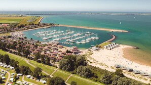 An aerial view of a marina with boats, a beach, and residential areas. - RBR 1654 - Beach Resort Kamperland by Interhome (Kamperland)