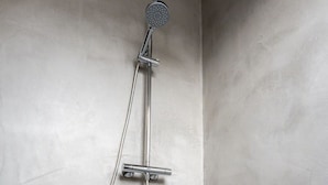 Een douche met een handdouche en een doucheslang.