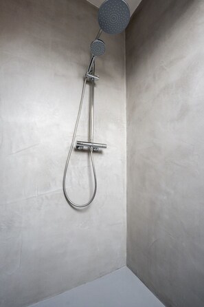 Eine Dusche mit Duschkopf und Handbrause.