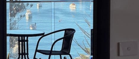Varanda com vista para uma marina e barcos à vela.