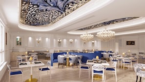 A spacious, elegantly decorated dining area with marble flooring, blue upholstered seating, and ornate chandeliers. - Sandals Dunn's River Falls (Ocho Rios)