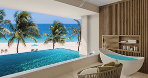 A modern bathroom with a bathtub, a wicker chair, and a view of a beach with palm trees. - Sandals Dunn's River Falls (Ocho Rios)