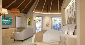 A bedroom with a bed, a chair, a table, and a TV. - Sandals Dunn's River Falls (Ocho Rios)