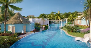 A resort with a swimming pool, palm trees, and thatched-roof buildings. - Sandals Dunn's River Falls (Ocho Rios)